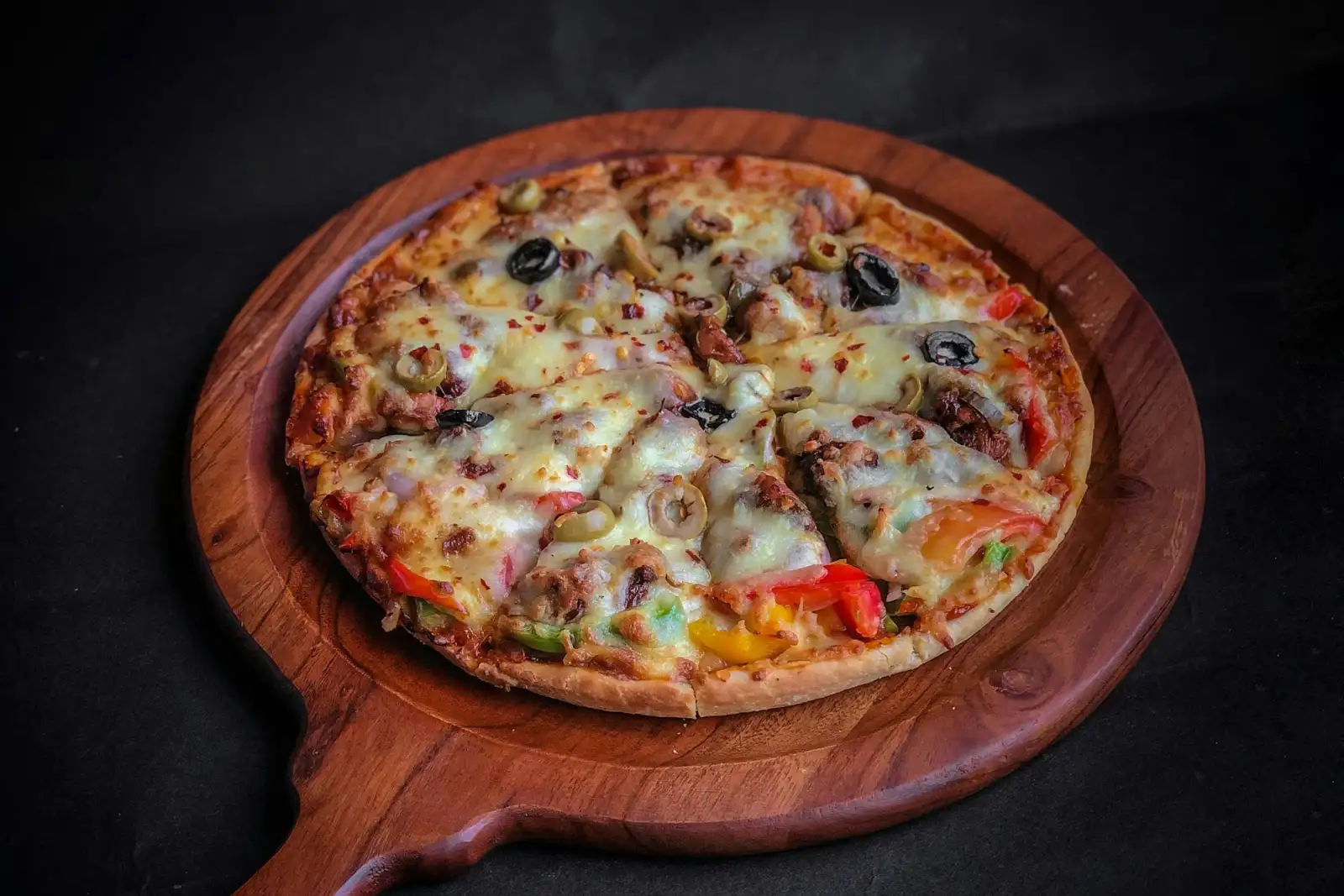 Bánh pizza vừa ra lò đặt trên khay gỗ